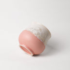 Ceramic cup with gradient pink and white crystalline color on a white background