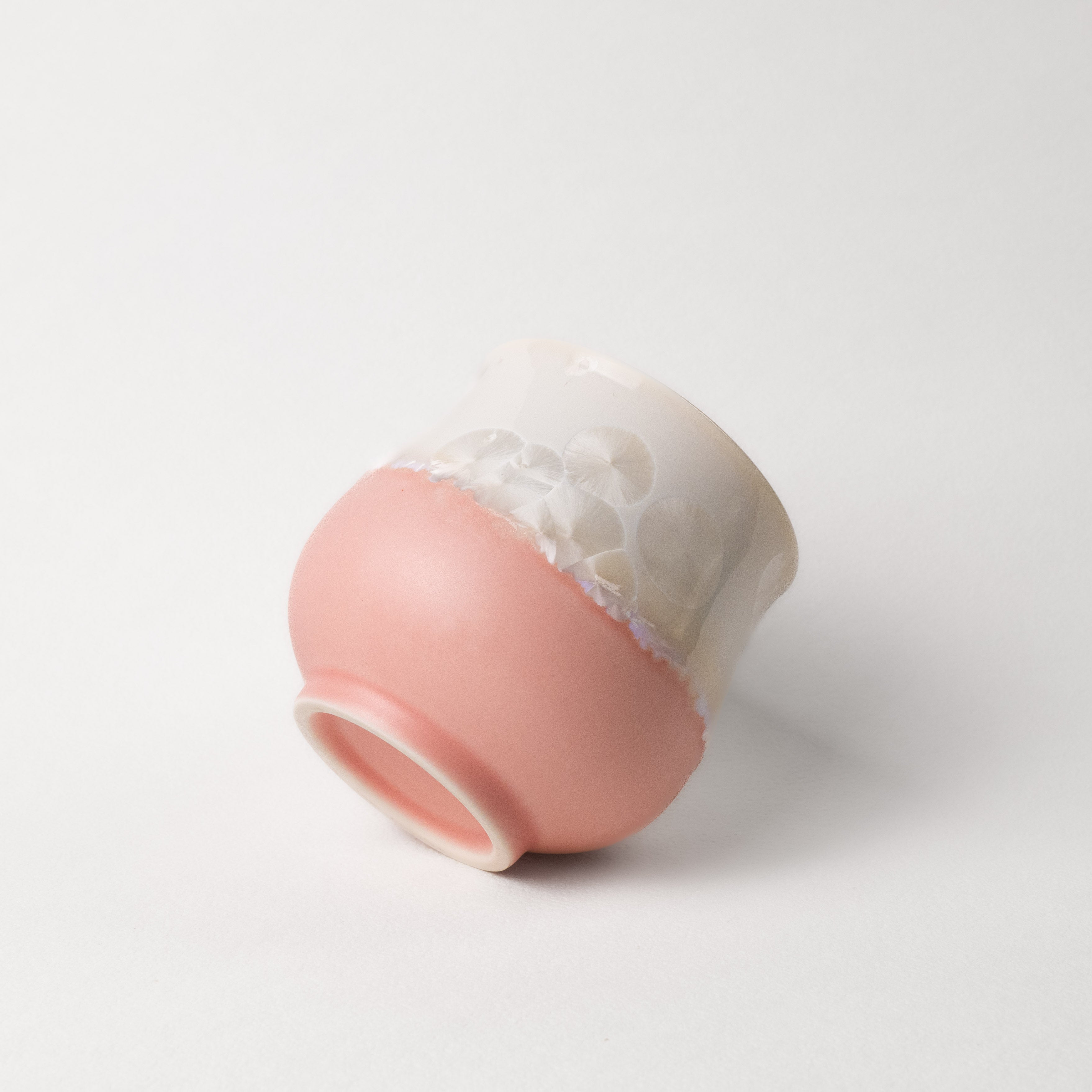 Ceramic cup with gradient pink and white crystalline color on a white background