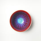 Ceramic tea cup with a vibrant, multicolored interior on a white background