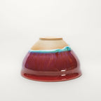 Red ceramic tea cup with a gradient from beige to red on a white background