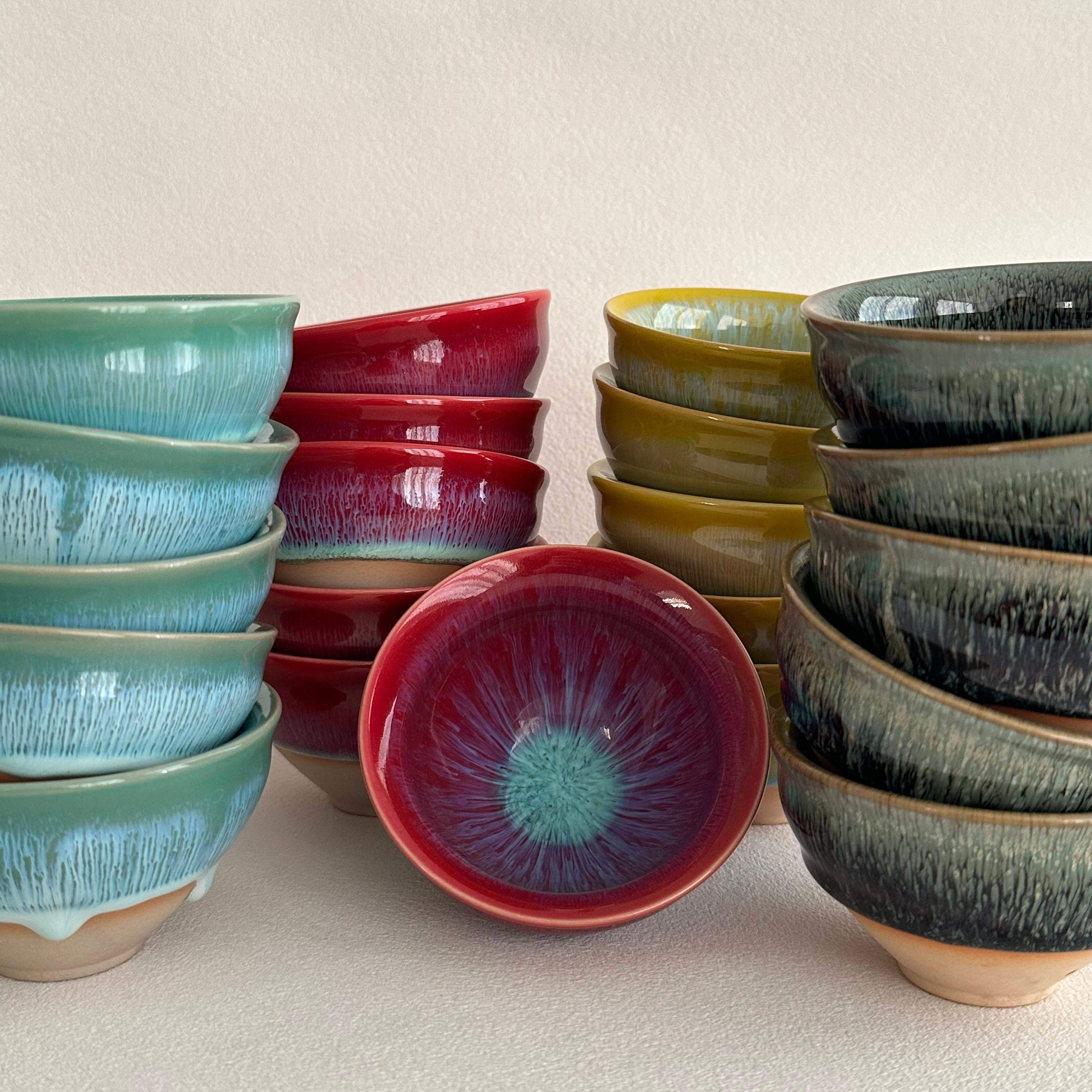 Set of ceramic bowls with different designs and colors on a beige background