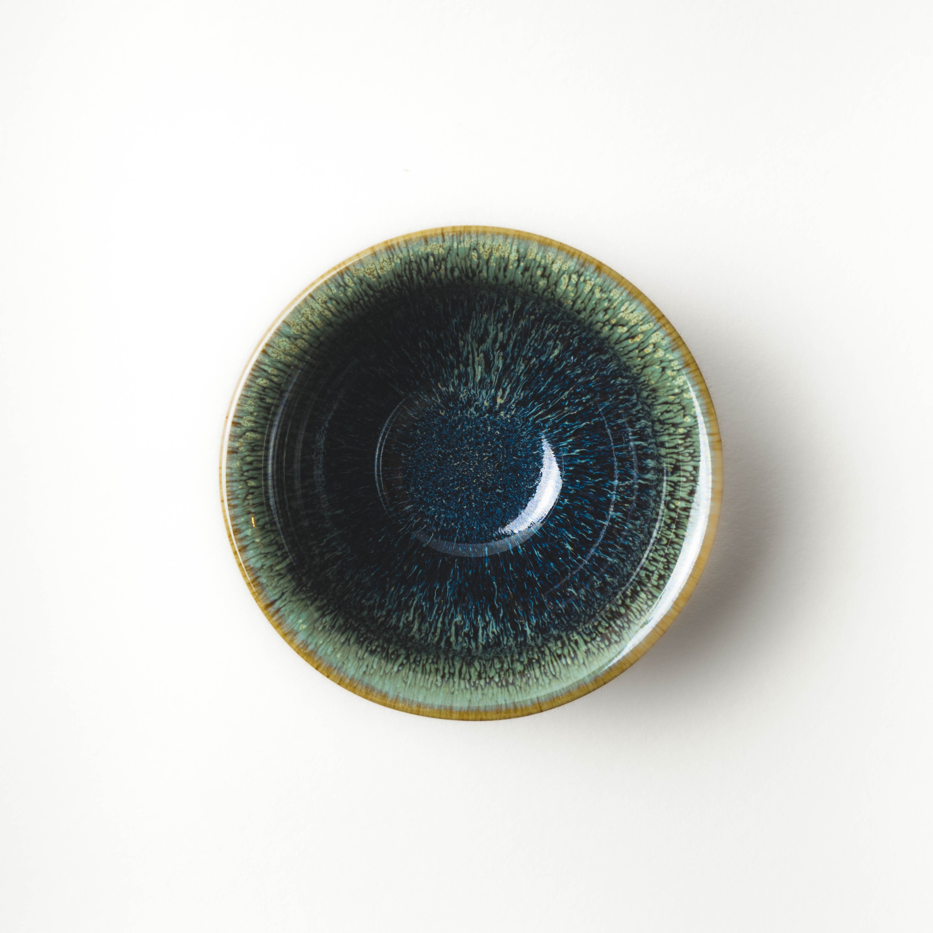 Green ceramic tea cup on a white background