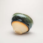 Ceramic tea cup with a green textured surface on a white background