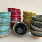 Set of ceramic bowls in various colors on a beige background