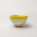 Yellow ceramic bowl on a light gray background