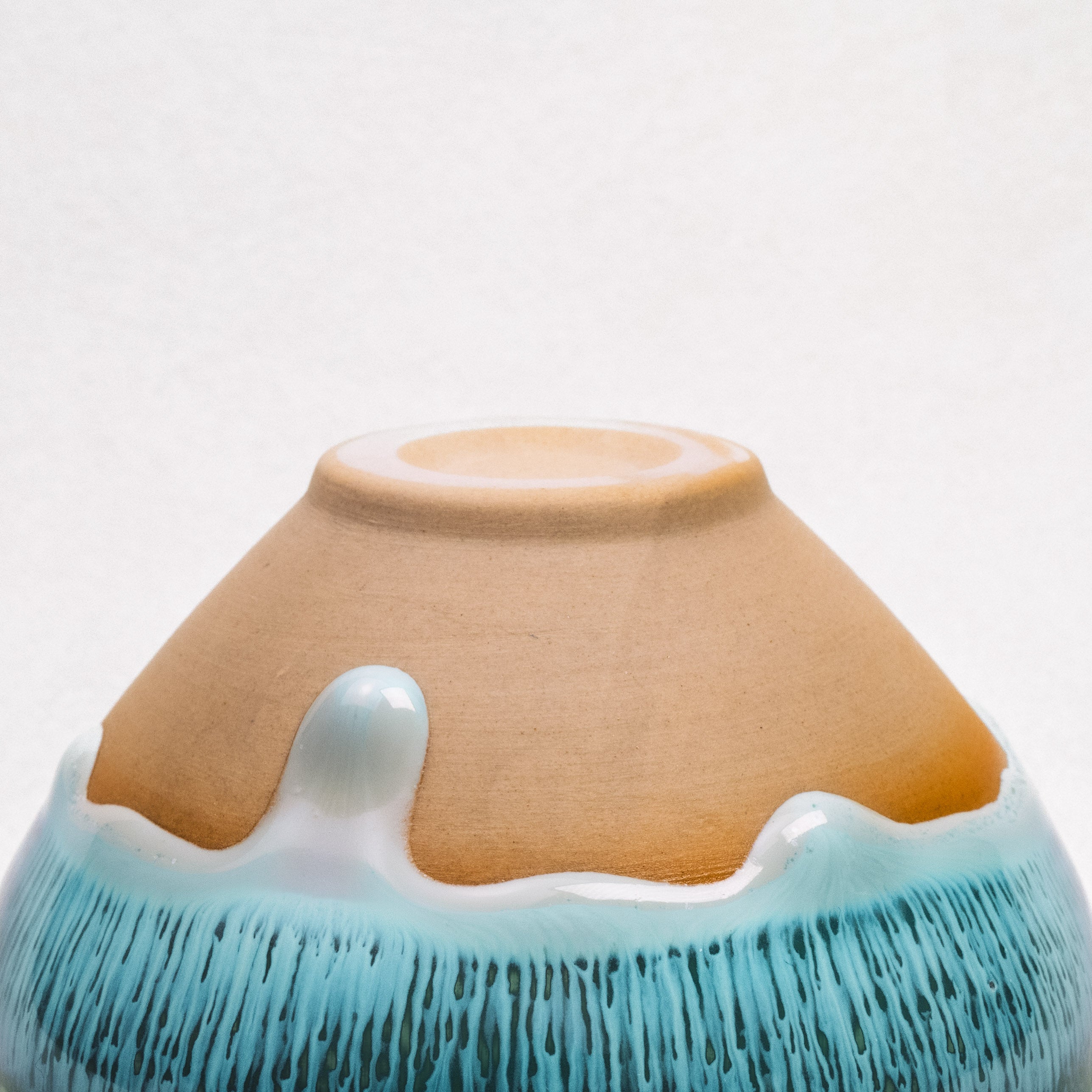 Ceramic tea cup with a design resembling Mount Fuji on a white background