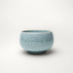 Light blue ceramic tea cup on a white background