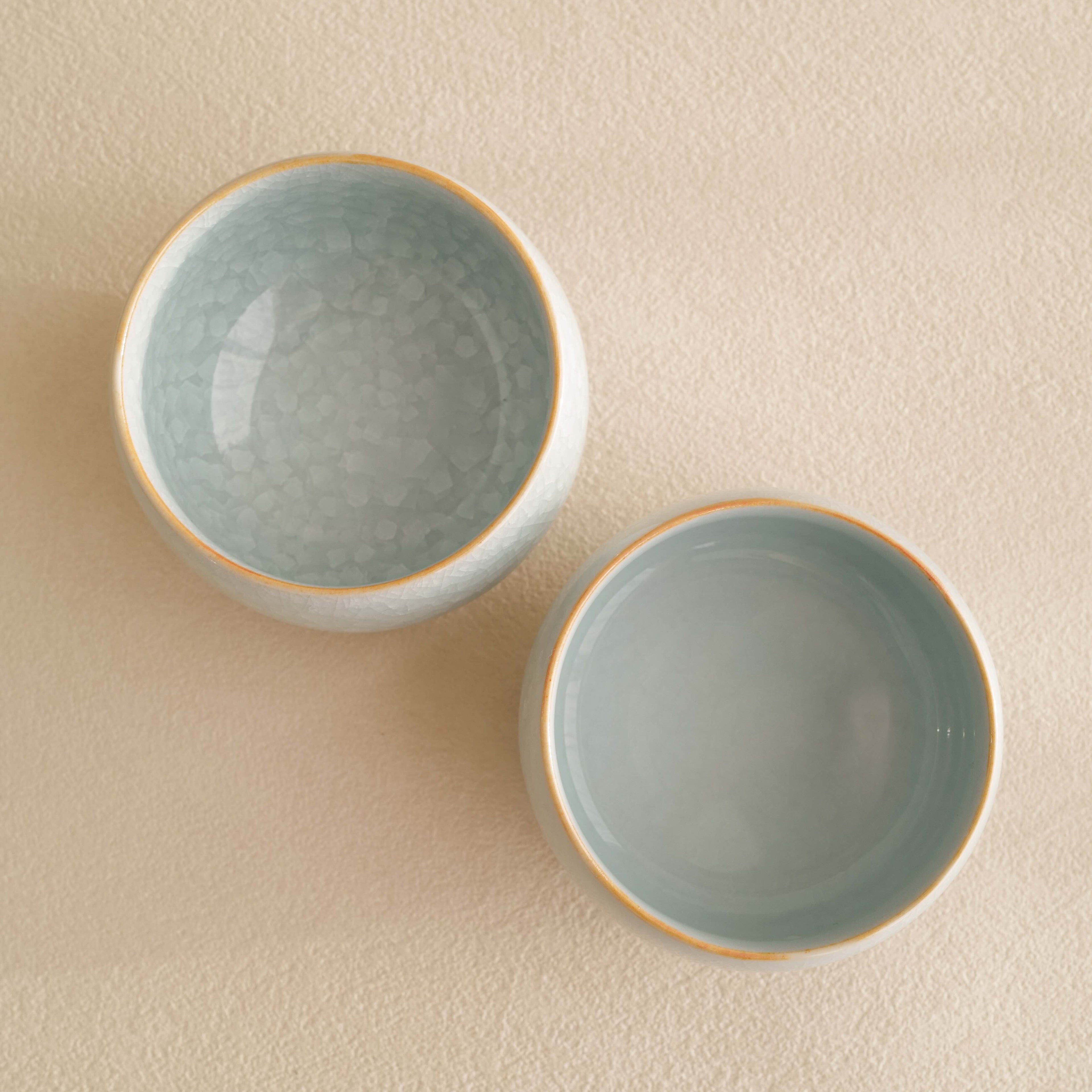 Two ceramic bowls with textured interior on a beige background