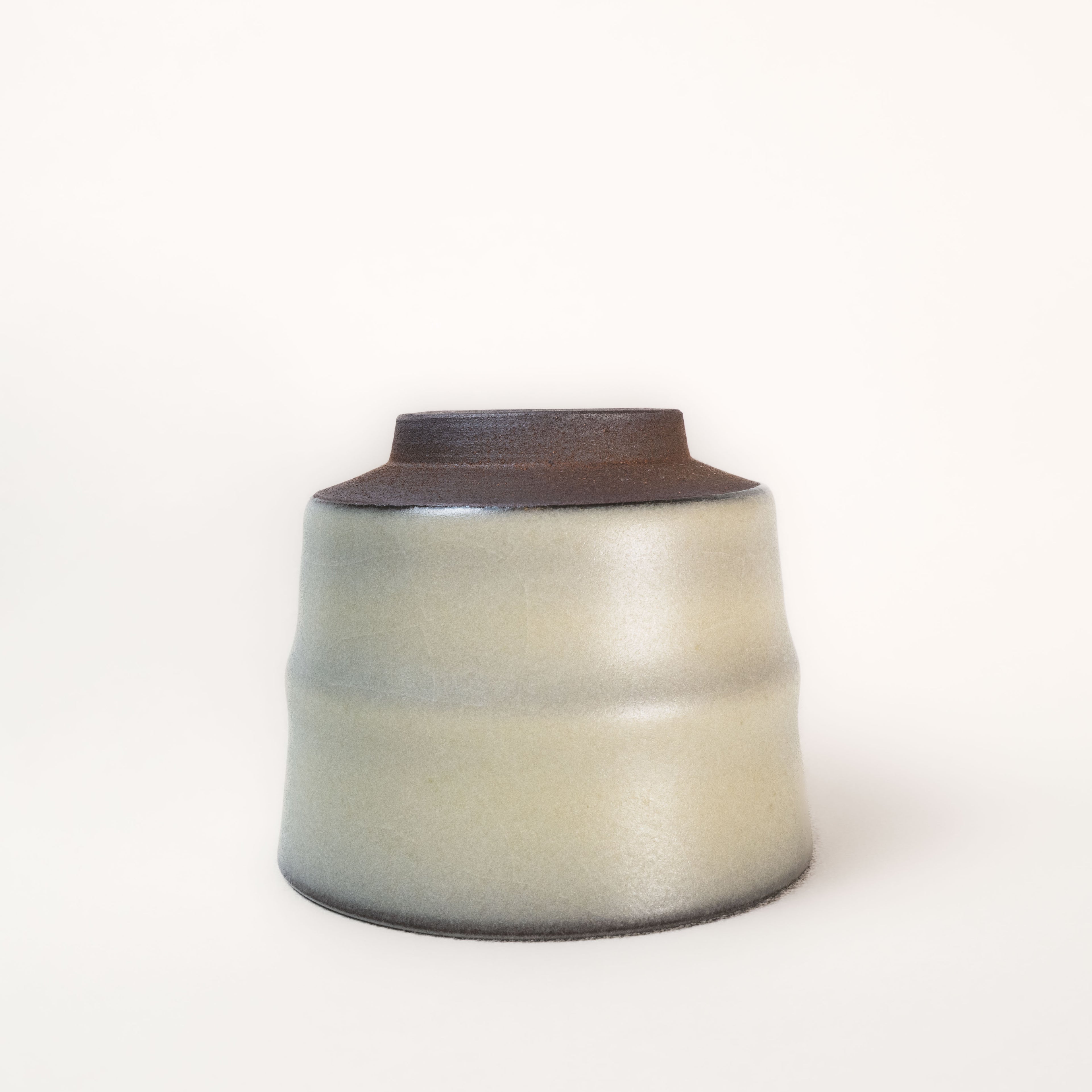 Ceramic tea cup with a two-tone design on a white background