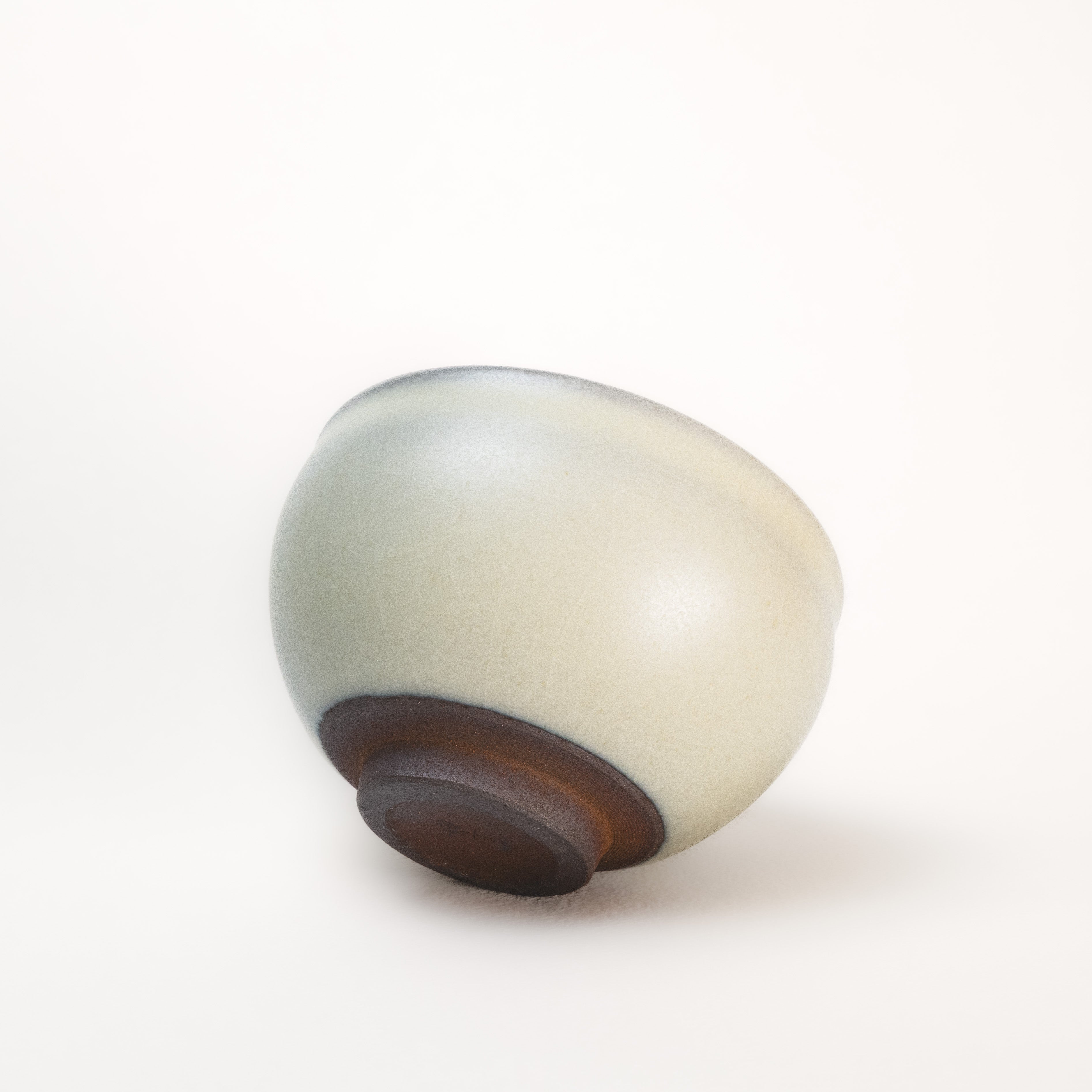 Round ceramic object with a two-tone design on a white background